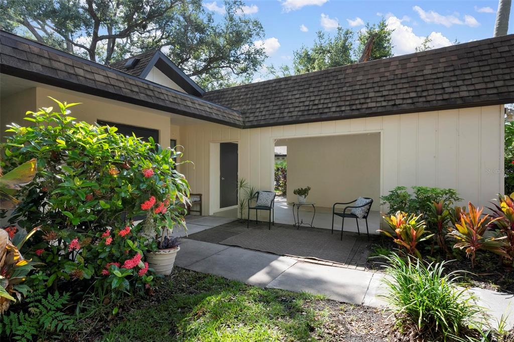 A paved patio area sits in front of a house with a covered entryway — 2227 CIRCLEWOOD DRIVE UNIT 52, SARASOTA, FL