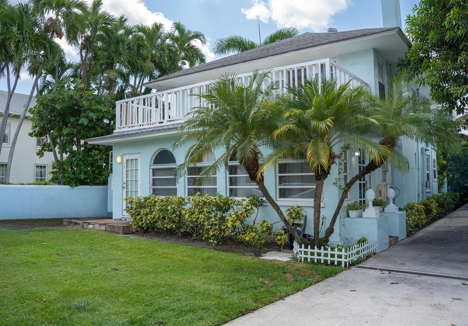 A two-story light blue house with a white balcony and palm trees in the front yard — 264 Seminole Avenue, Palm Beach FL 33480, PALM BEACH, FL