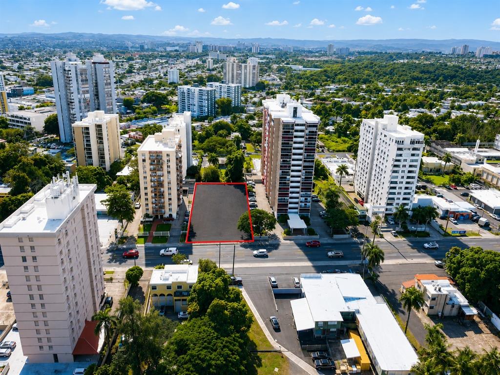 An aerial view shows a vacant rectangular lot outlined in red between two apartment buildings — carr. 2 KM 6.4 VILLA CAPARRA, GUAYNABO, PR