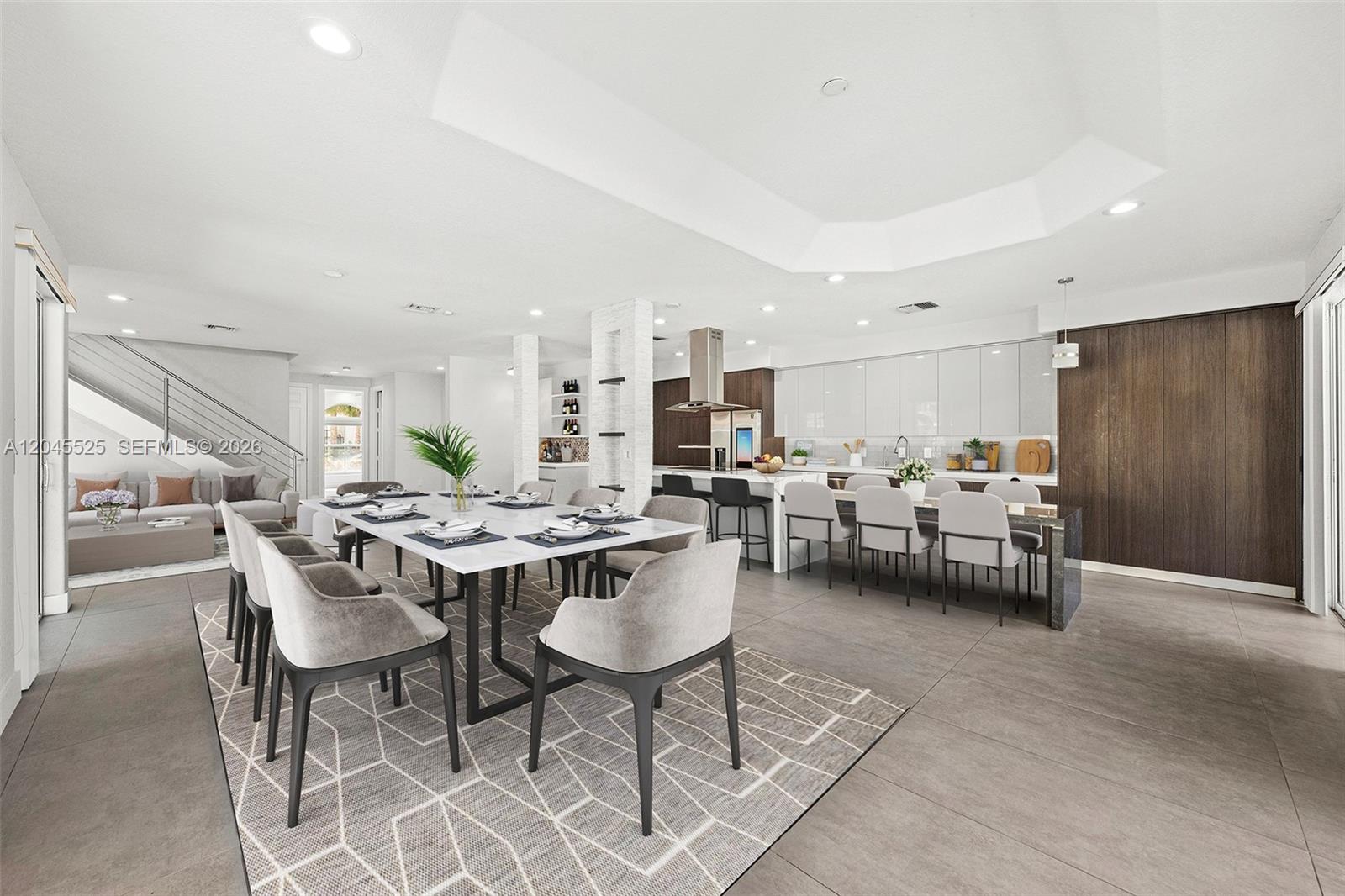A modern open-concept dining area and kitchen featuring a large table and island seating — 1549 Shoreline Way, Hollywood FL 33019, HOLLYWOOD, FL