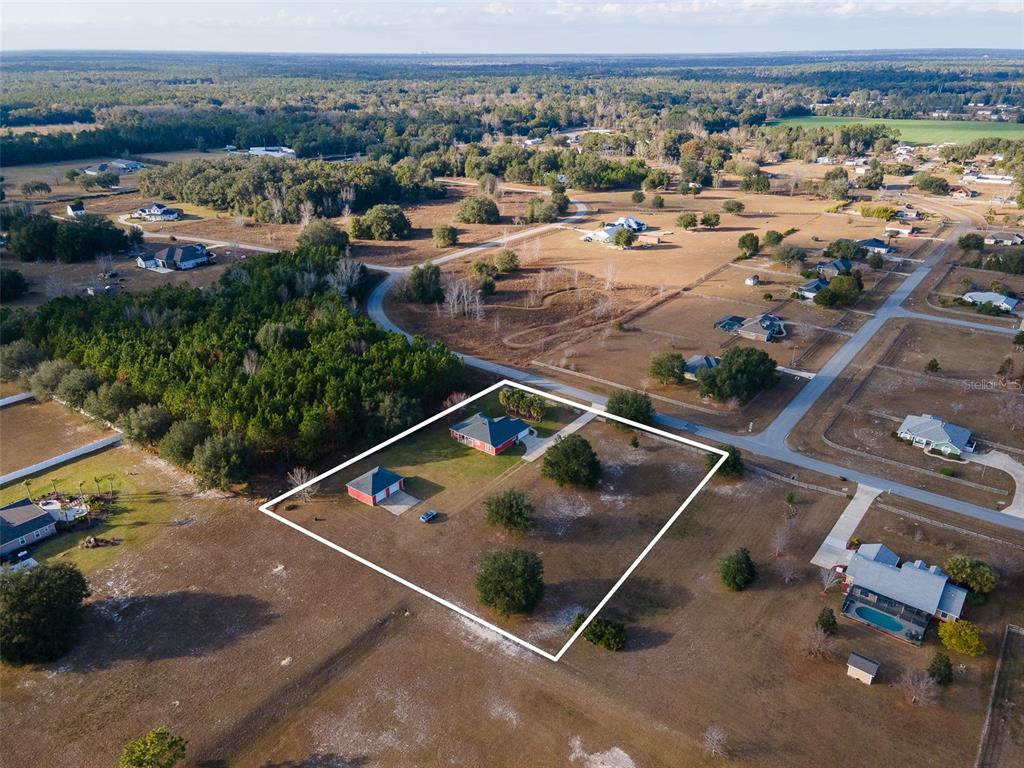 An aerial view shows a house and detached garage on a large, fenced-in lot — 10215 SW 98 TH AVENUE, GAINESVILLE, FL