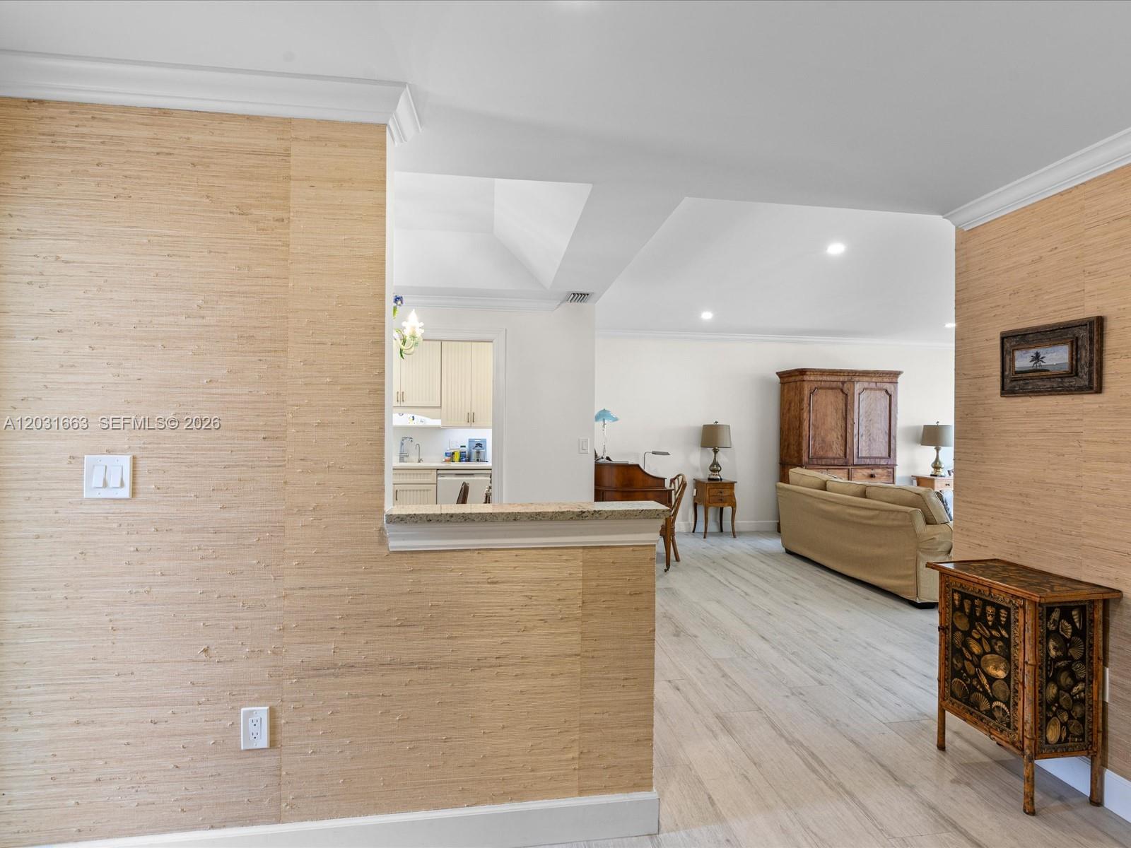 A living room and kitchen are visible beyond a wall covered in textured wallpaper — 2160 Ibis Isle Rd # 3, Palm Beach FL 33480, PALM BEACH, FL