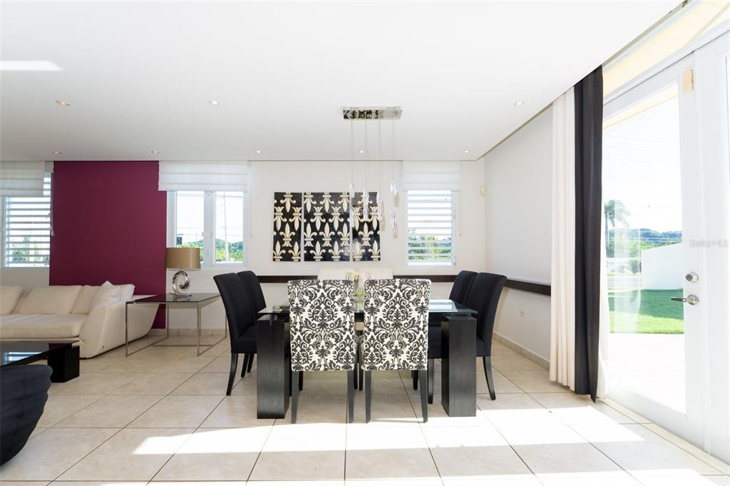 A dining room features a glass table, patterned chairs, and a large purple accent wall — 797 MAR DE CASPIO, DORADO, PR