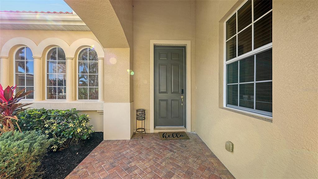 A front entryway features a gray door, a brick porch, and a large window — 121 SAVONA WAY, NOKOMIS, FL