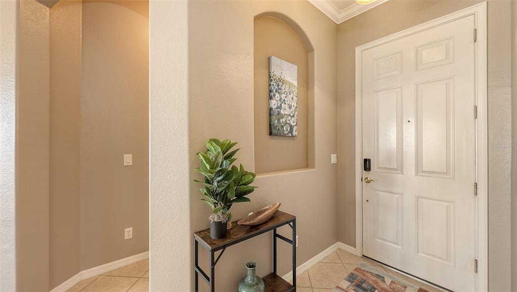 An entryway features a white front door, a decorative wall niche, and a small console table — 121 SAVONA WAY, NOKOMIS, FL