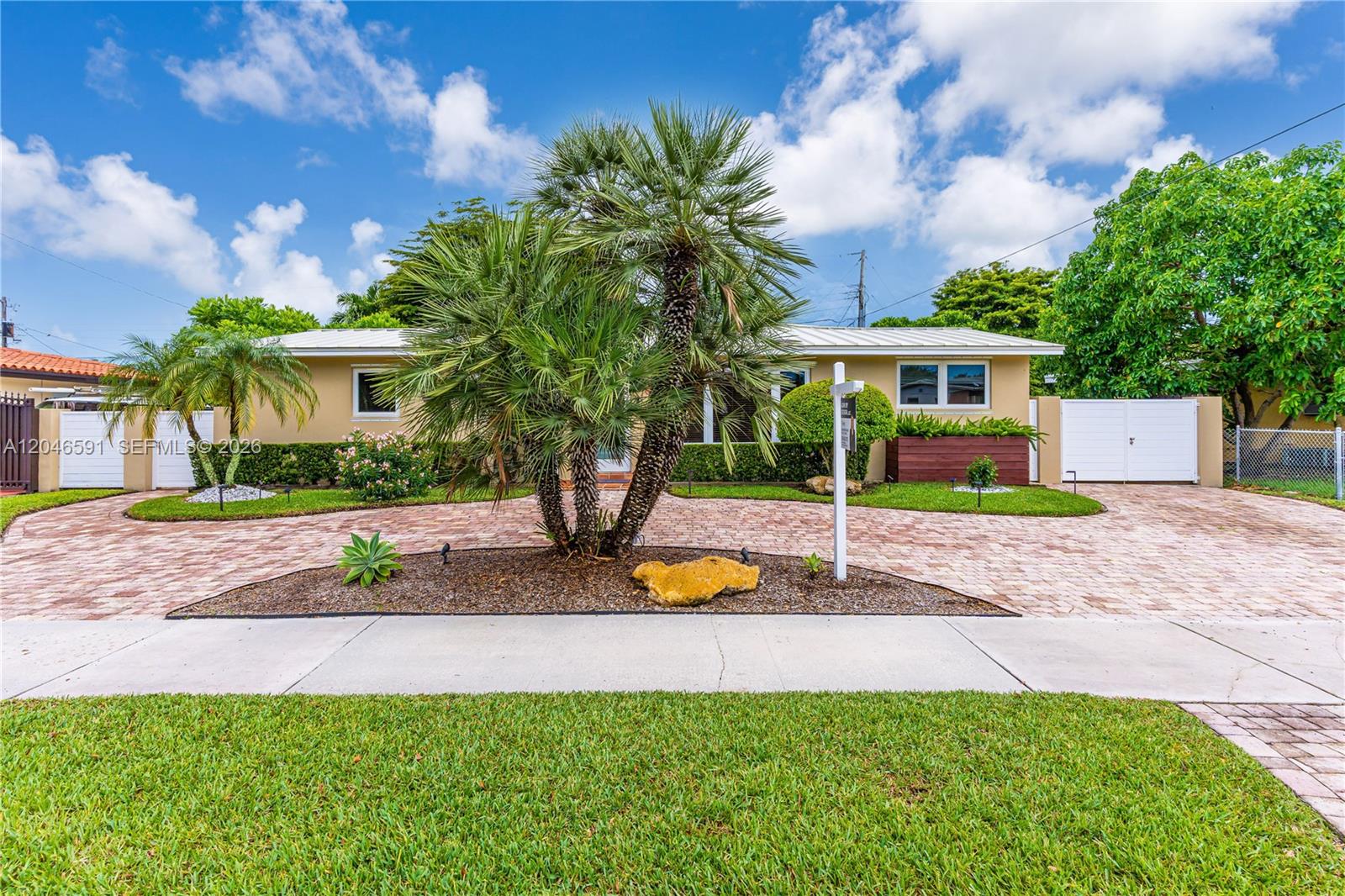 A single-story house with a paved driveway, a central palm tree, and a grassy lawn — 11180 SW 58th Ter, Miami FL 33173, MIAMI, FL