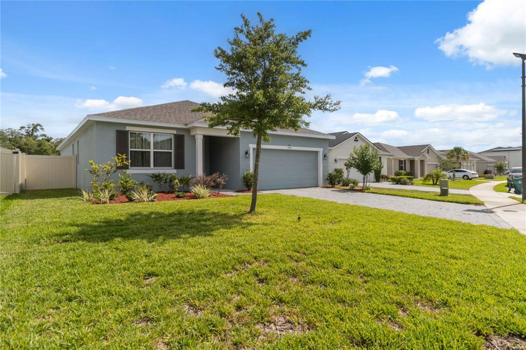 A single-story suburban house with a gray exterior, a two-car garage, and a front lawn — 905 HONEY PETAL LANE, DELAND, FL