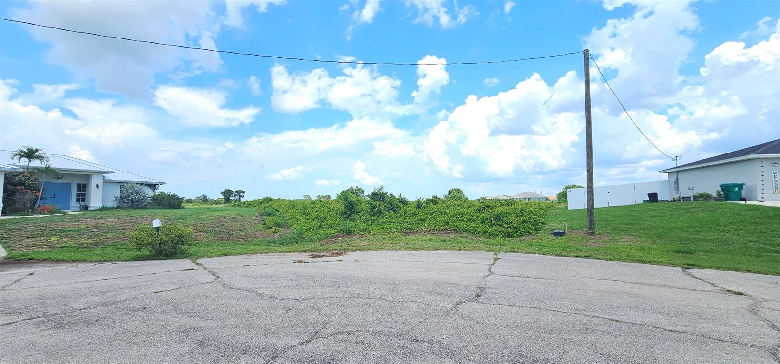 A vacant, grassy lot sits between two suburban houses at the end of a cul-de-sac — 9009 Tea Court, FL 33935, FL