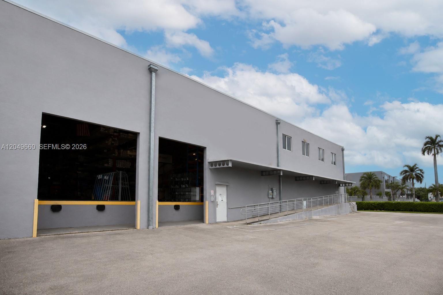 A gray industrial warehouse building features two loading bays, a pedestrian door, and a ramp — 2290 W 8th Ave, Hialeah FL 33010, HIALEAH, FL
