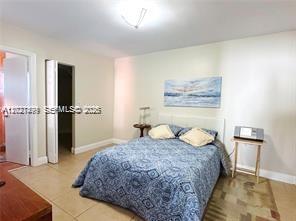 A bedroom features a bed with a blue patterned comforter, a small side table, and closet — 3305 SW 114 CT # 2, Miami FL 33165, MIAMI, FL