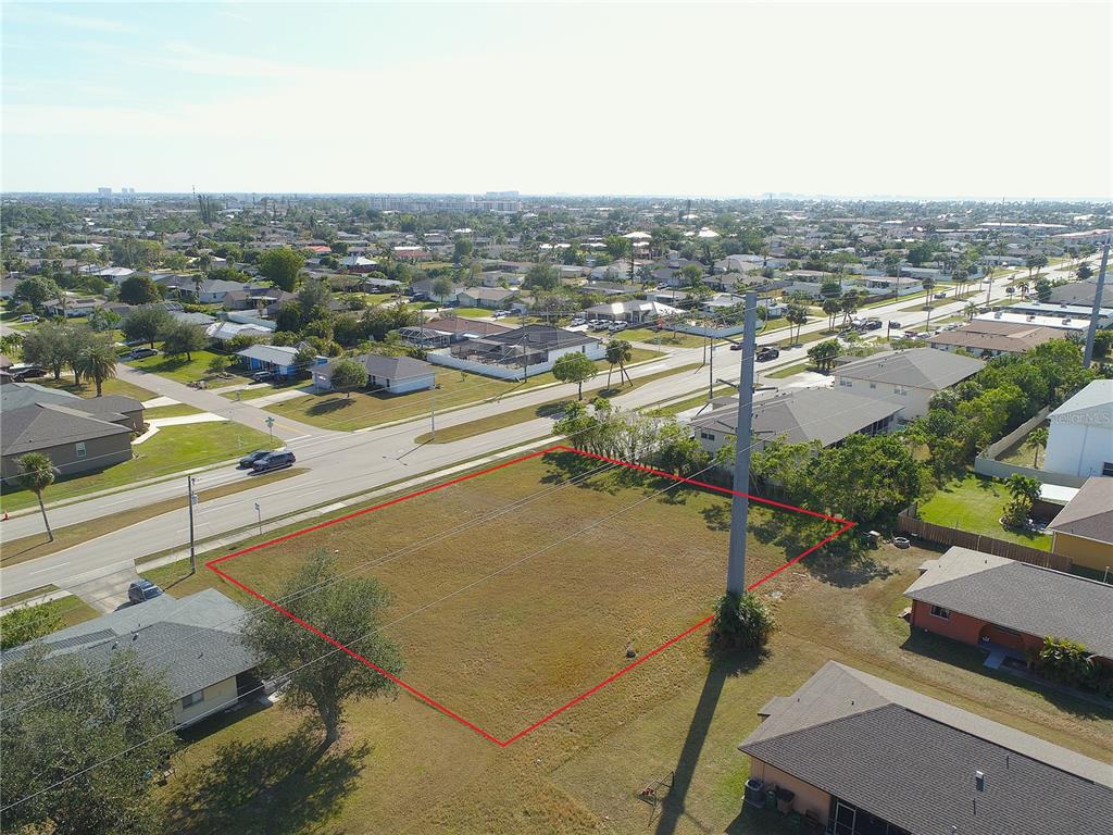 An aerial view shows a vacant rectangular lot outlined in red next to a road — 4412 SANTA BARBARA BOULEVARD, CAPE CORAL, FL