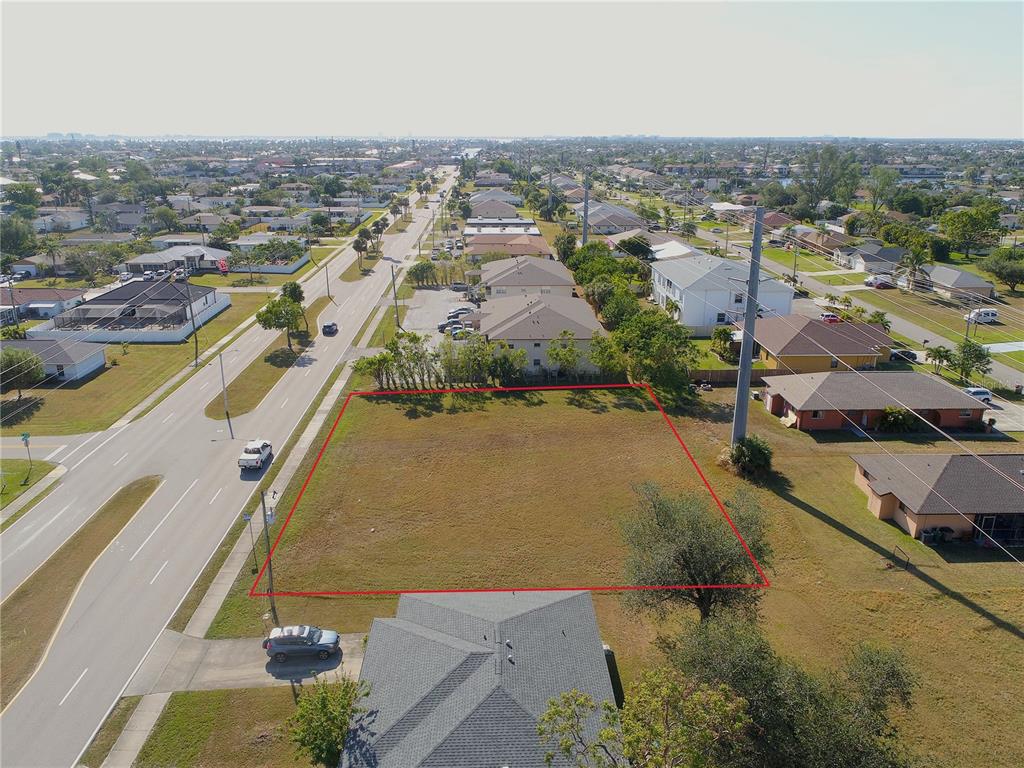 An aerial view shows a vacant, rectangular lot outlined in red next to a road — 4412 SANTA BARBARA BOULEVARD, CAPE CORAL, FL