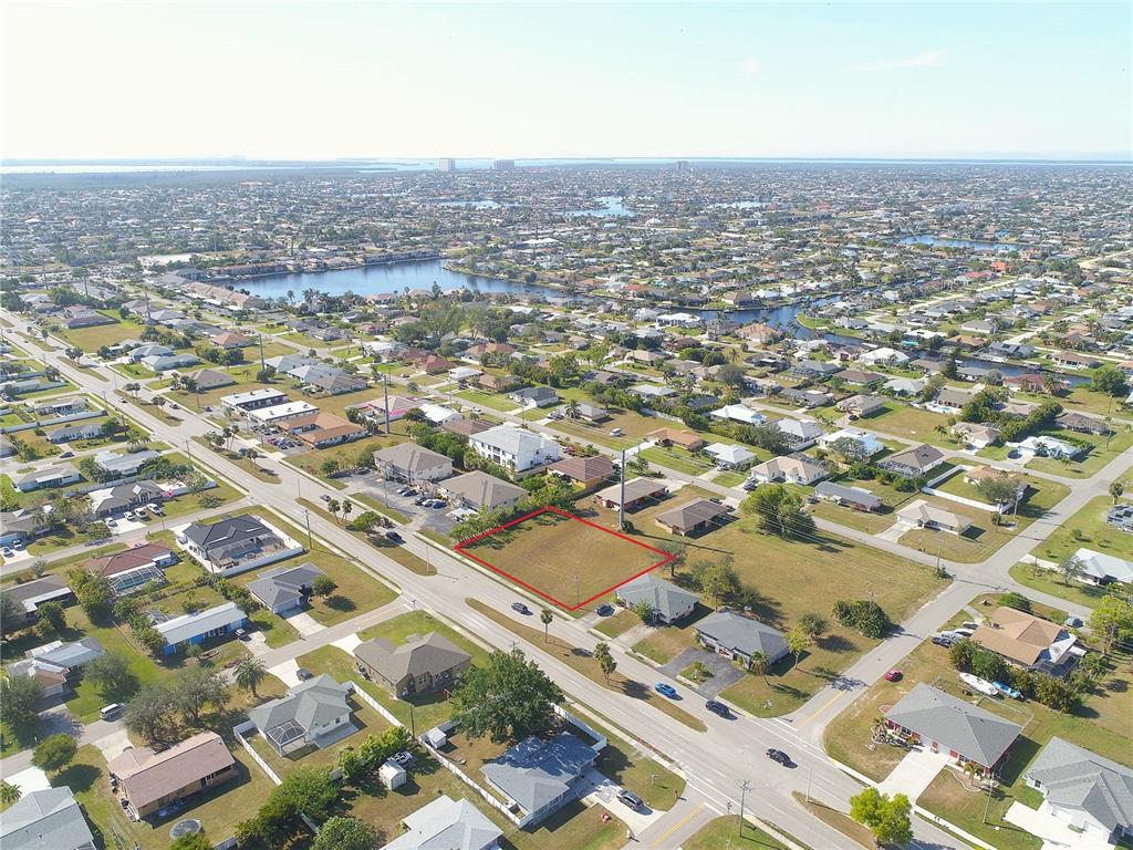 An aerial view shows a vacant, rectangular lot outlined in red within a residential neighborhood — 4412 SANTA BARBARA BOULEVARD, CAPE CORAL, FL