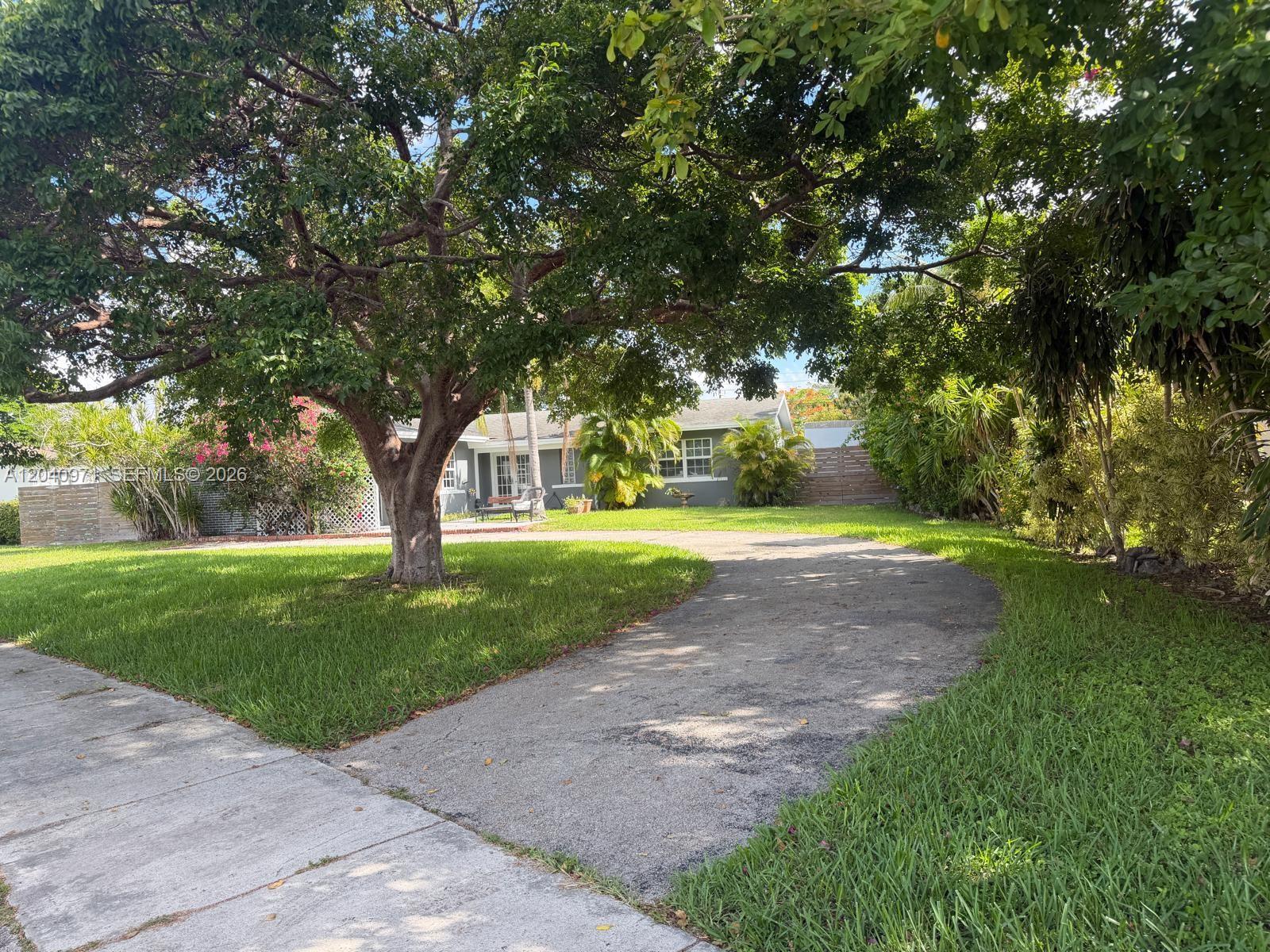 A paved driveway leads to a gray house shaded by a large tree — 12551 SW 35th St, Miami FL 33175, MIAMI, FL