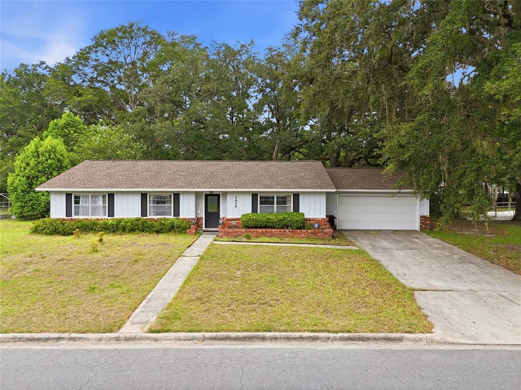 A single-story house with a white exterior, brick accents, and an attached garage — 4628 NW 40TH STREET, GAINESVILLE, FL