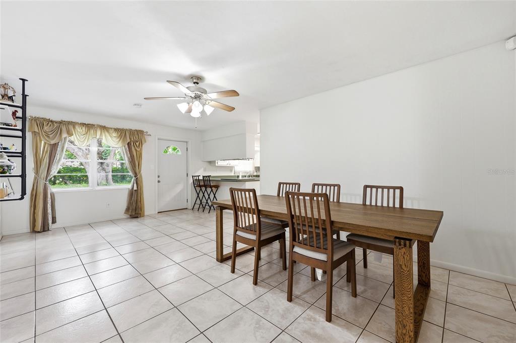 A dining area features a wooden table, six chairs, tile flooring, and a ceiling fan — 4628 NW 40TH STREET, GAINESVILLE, FL