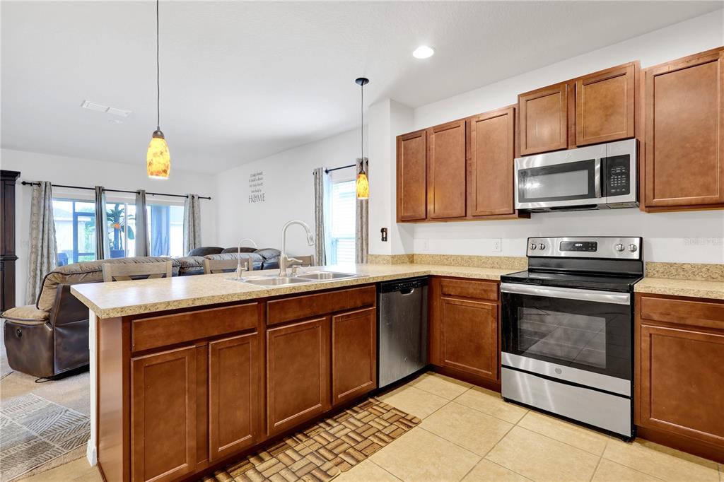 A kitchen with wood cabinets, stainless steel appliances, and a breakfast bar island — 4817 MARCOS CIRCLE, KISSIMMEE, FL