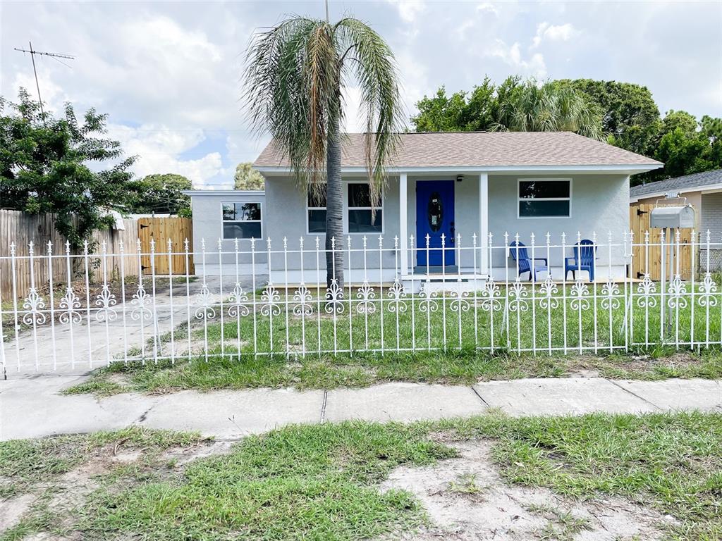 A single-story house with a blue front door, a white fence, and a palm tree — 4537 10TH AVENUE S, ST PETERSBURG, FL