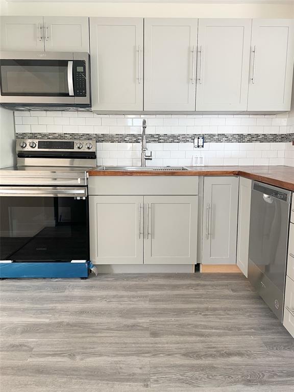 A kitchen features gray cabinets, stainless steel appliances, a wood countertop, and a subway tile backsplash — 4537 10TH AVENUE S, ST PETERSBURG, FL