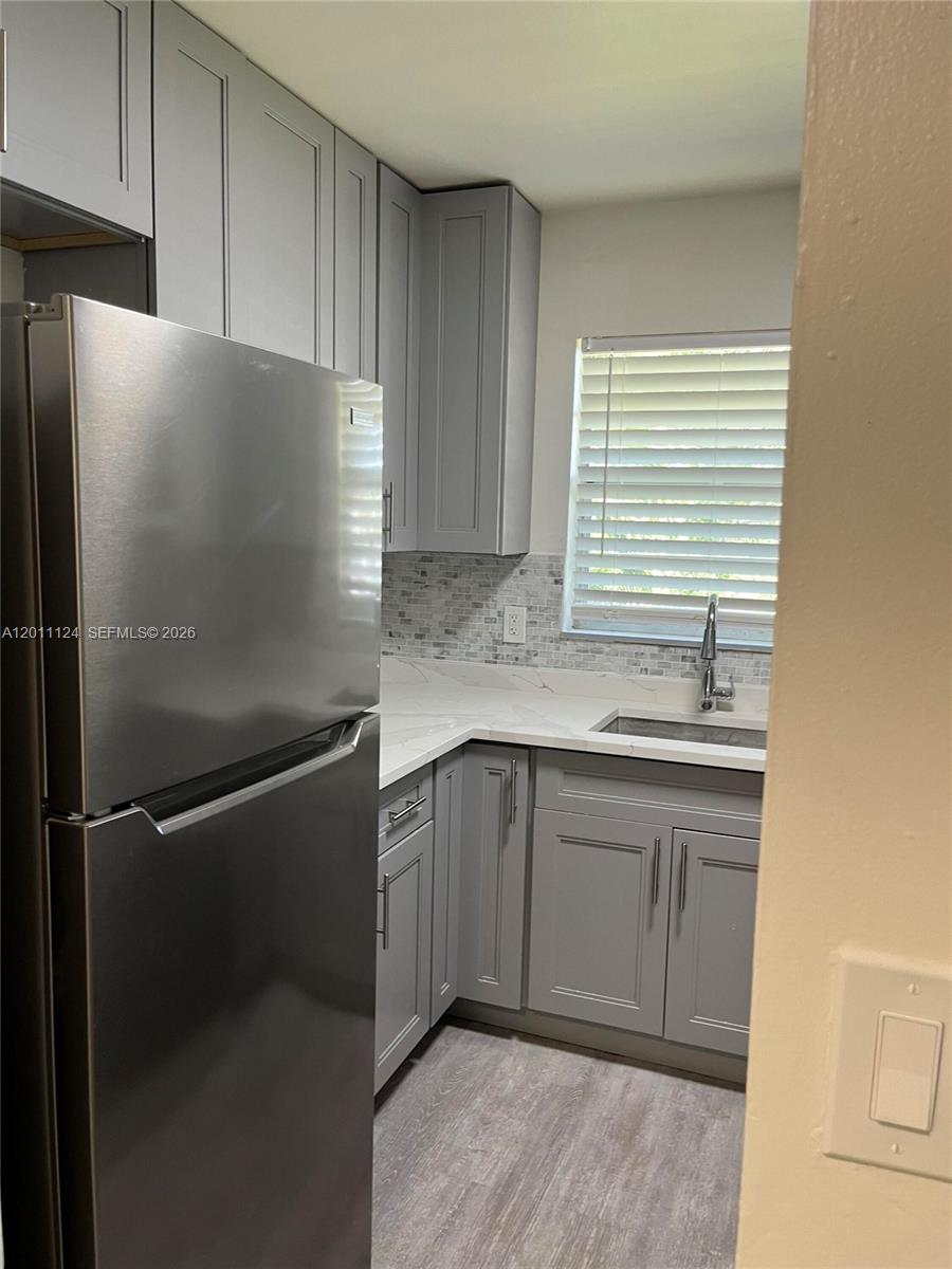 A kitchen features gray cabinets, stainless steel appliances, white countertops, and a tiled backsplash — 2134 Lincoln St # 18, Hollywood FL 33020, HOLLYWOOD, FL