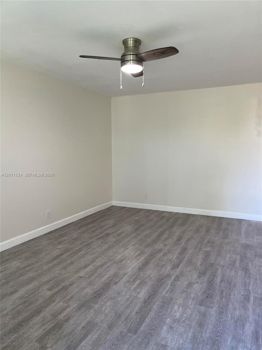 An empty room features light-colored walls, gray wood-look flooring, and a ceiling fan — 2134 Lincoln St # 18, Hollywood FL 33020, HOLLYWOOD, FL