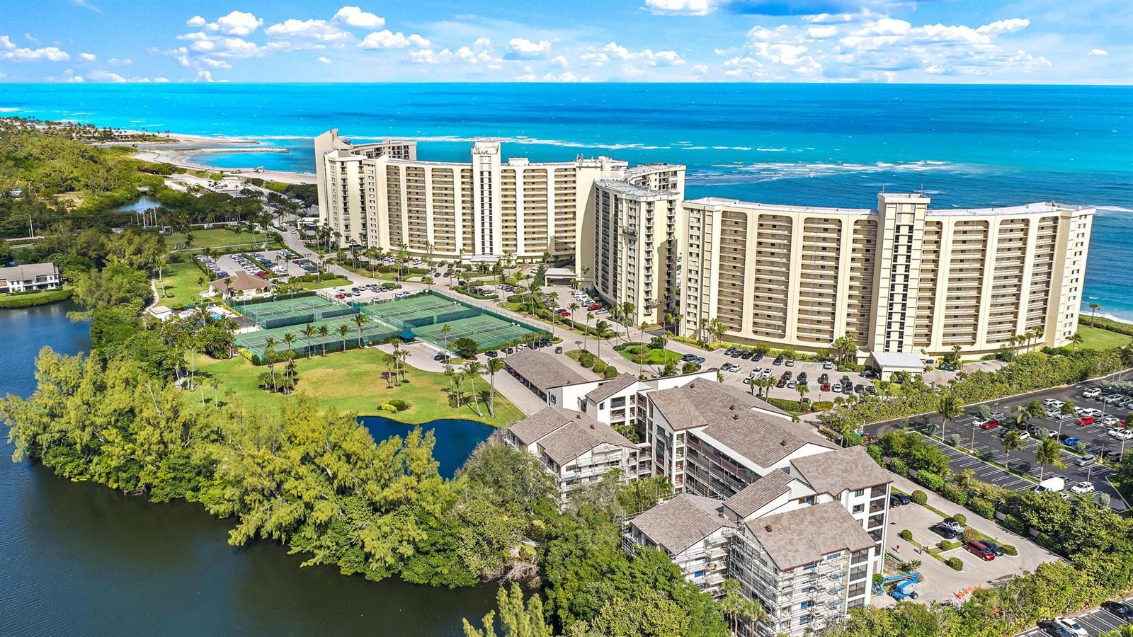 An aerial view shows a large beachfront resort complex with tennis courts and parking lots — 500 Ocean Trail Way # 305, Jupiter FL 33477, JUPITER, FL