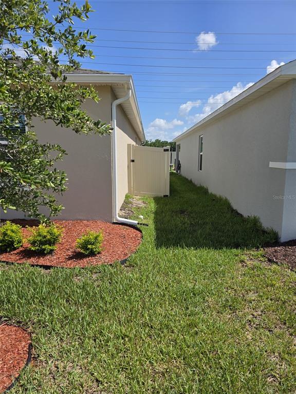 The exterior view shows a narrow grassy side yard between two beige residential houses — 559 WAYLAND DRIVE, HAINES CITY, FL