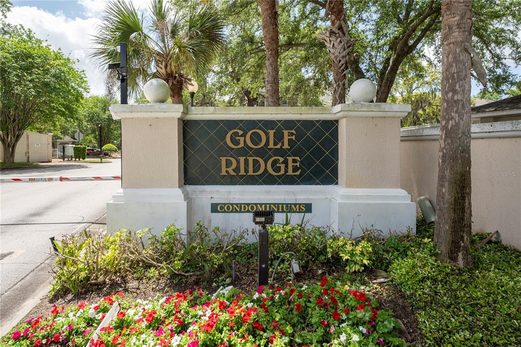 A sign for Golf Ridge Condominiums stands in front of a gated entrance with landscaping — 1212 S HIAWASSEE ROAD UNIT 525, ORLANDO, FL