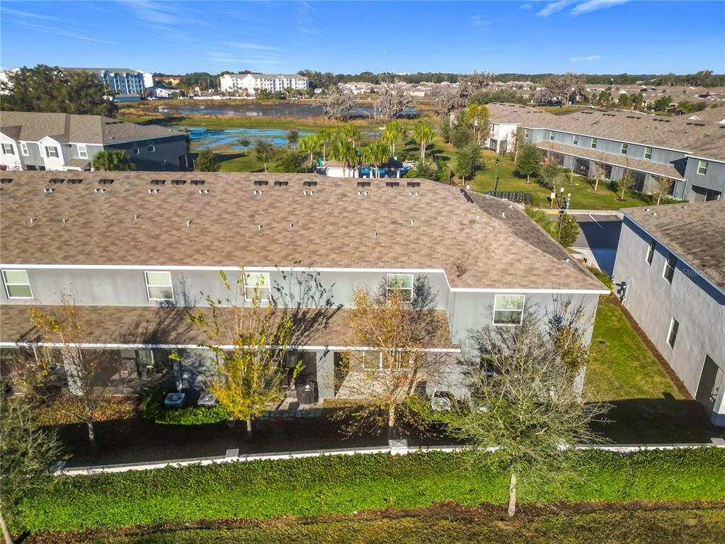 An aerial view of a multi-unit residential building with a grey exterior and shingled roof — 5391 DRAGONFLY DRIVE, WILDWOOD, FL
