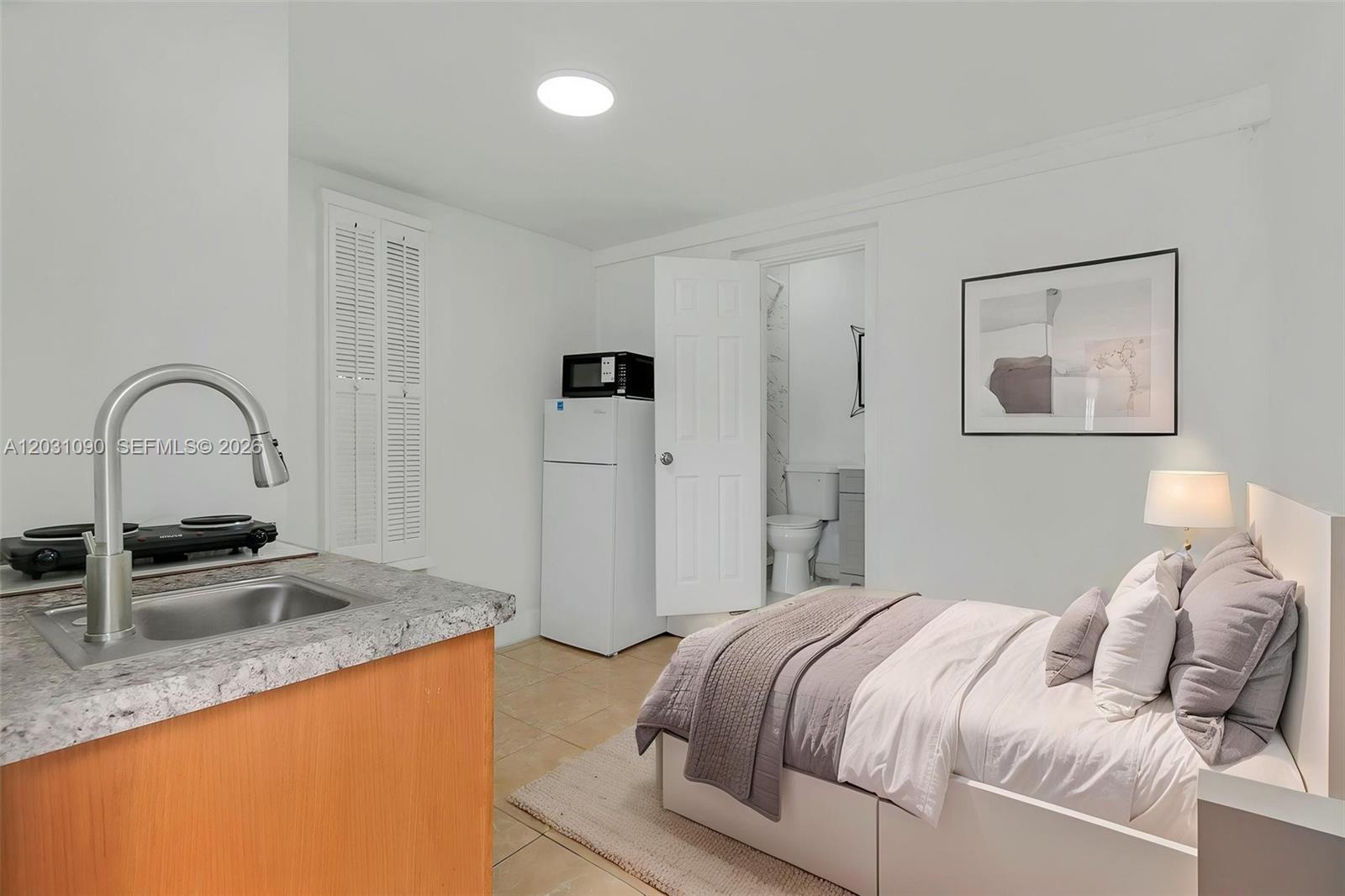 A studio apartment features a small kitchenette, a bed, and an attached bathroom — 6101 SW 24th St # 4, Miramar FL 33023, MIRAMAR, FL