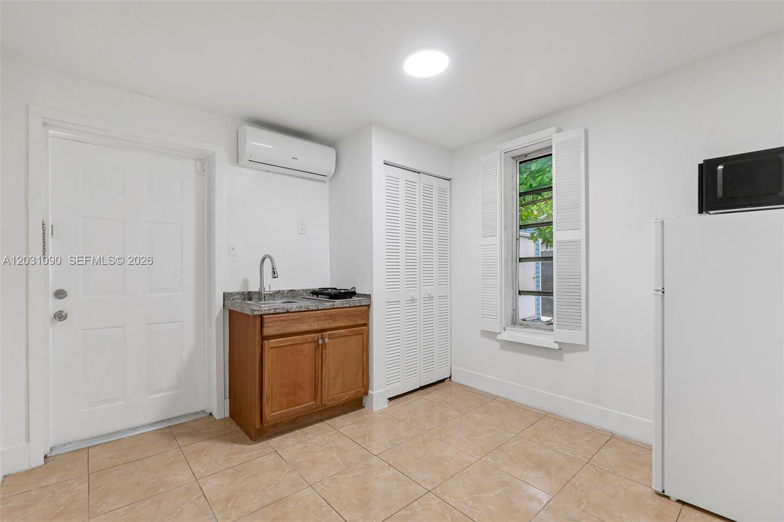 A small kitchen area features a sink, cabinetry, a refrigerator, and a window — 6101 SW 24th St # 4, Miramar FL 33023, MIRAMAR, FL