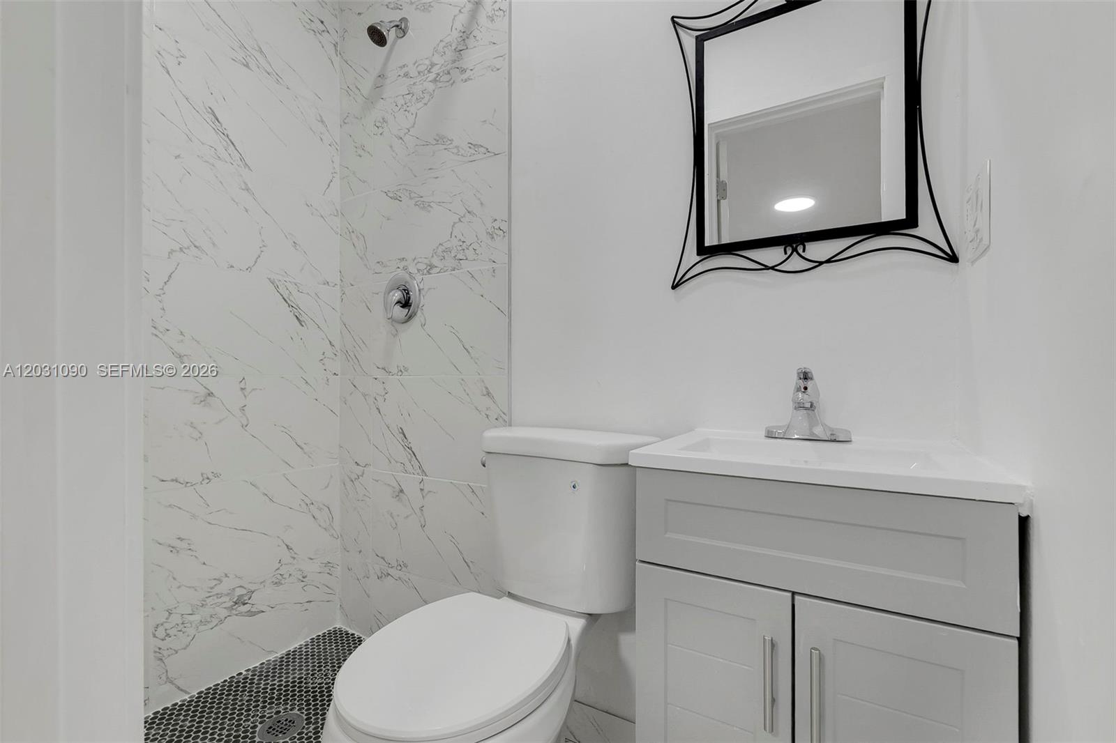 A bathroom features a marble-tiled shower, a white toilet, and a grey vanity with a mirror — 6101 SW 24th St # 4, Miramar FL 33023, MIRAMAR, FL