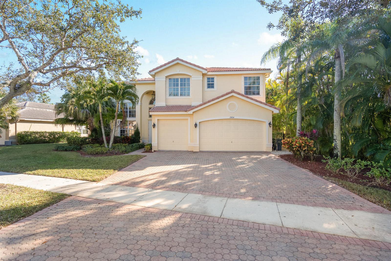 A two-story house with a paved driveway, two-car garage, and palm trees in the yard — 19434 Estuary Drive, Boca Raton FL 33498, BOCA RATON, FL