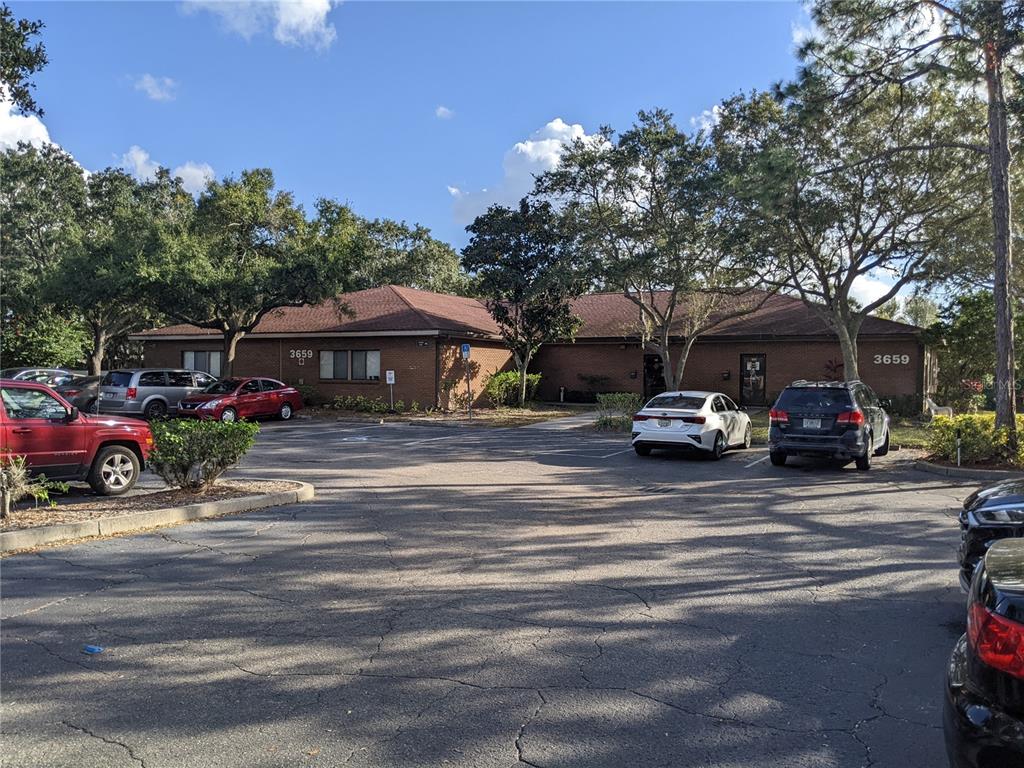 A single-story brick commercial building with a parking lot and surrounding trees — 3653 CORTEZ ROAD W UNIT 110, BRADENTON, FL