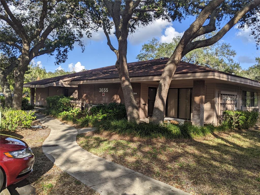 A single-story building with a brown roof, brick facade, and a concrete walkway — 3653 CORTEZ ROAD W UNIT 110, BRADENTON, FL