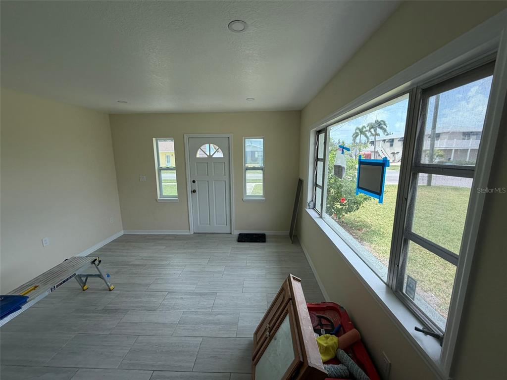 A single-story light green house with a palm tree in the front yard — 3803 117TH ST W, BRADENTON, FL