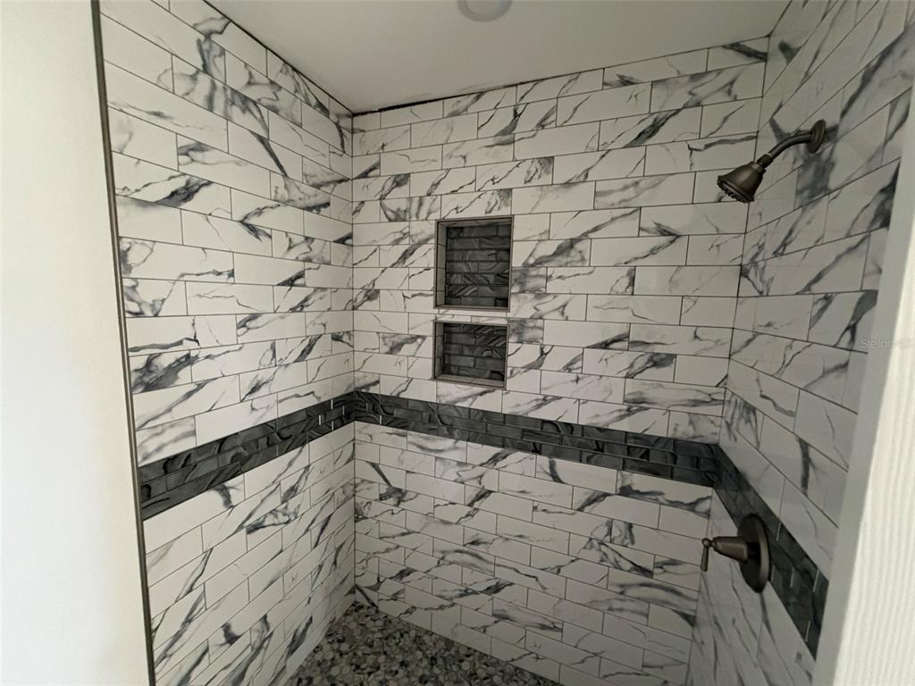 An empty room features light-colored walls, gray wood-look tile flooring, and two white doors — 3803 117TH ST W, BRADENTON, FL