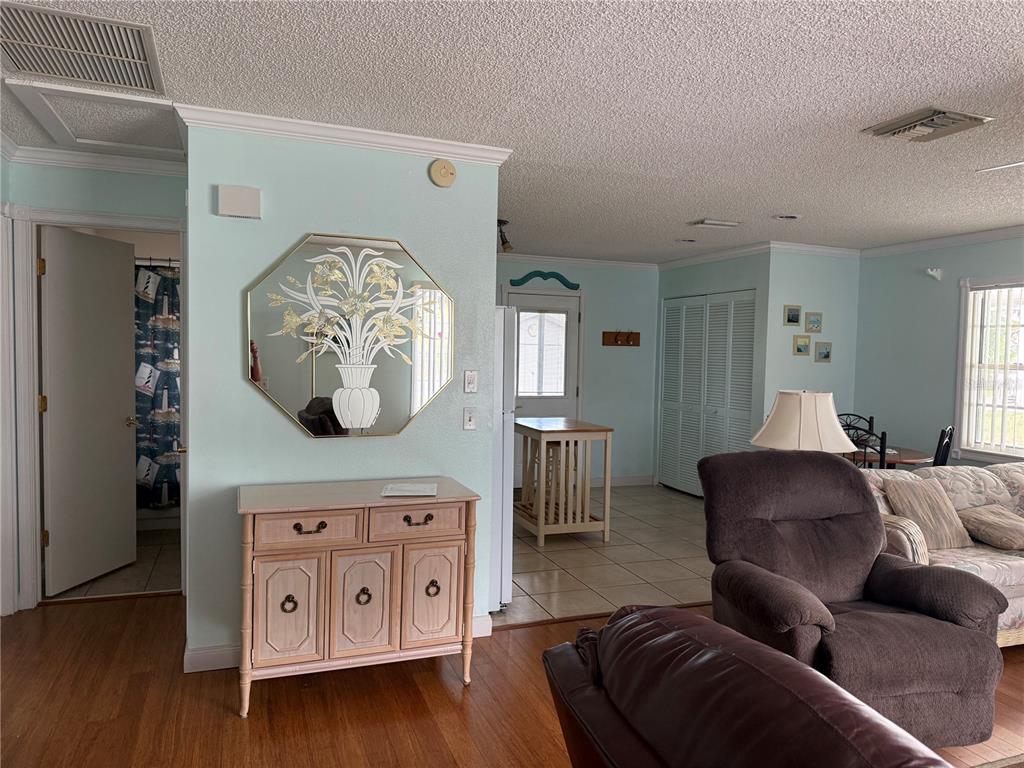 A living room with light blue walls, a wooden console table, and a large mirror — 12131 ROCKFORD STREET, SPRING HILL, FL