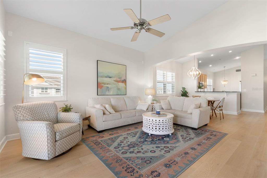 A living room features light-colored sofas, a patterned rug, and an open-concept kitchen — 400 CINNAMON BEACH WAY UNIT 365, PALM COAST, FL