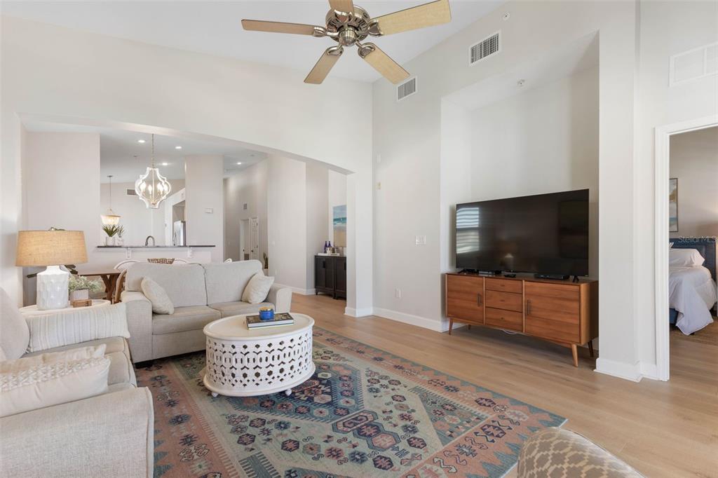 A living room features a vaulted ceiling, a ceiling fan, and a sliding glass door — 400 CINNAMON BEACH WAY UNIT 365, PALM COAST, FL