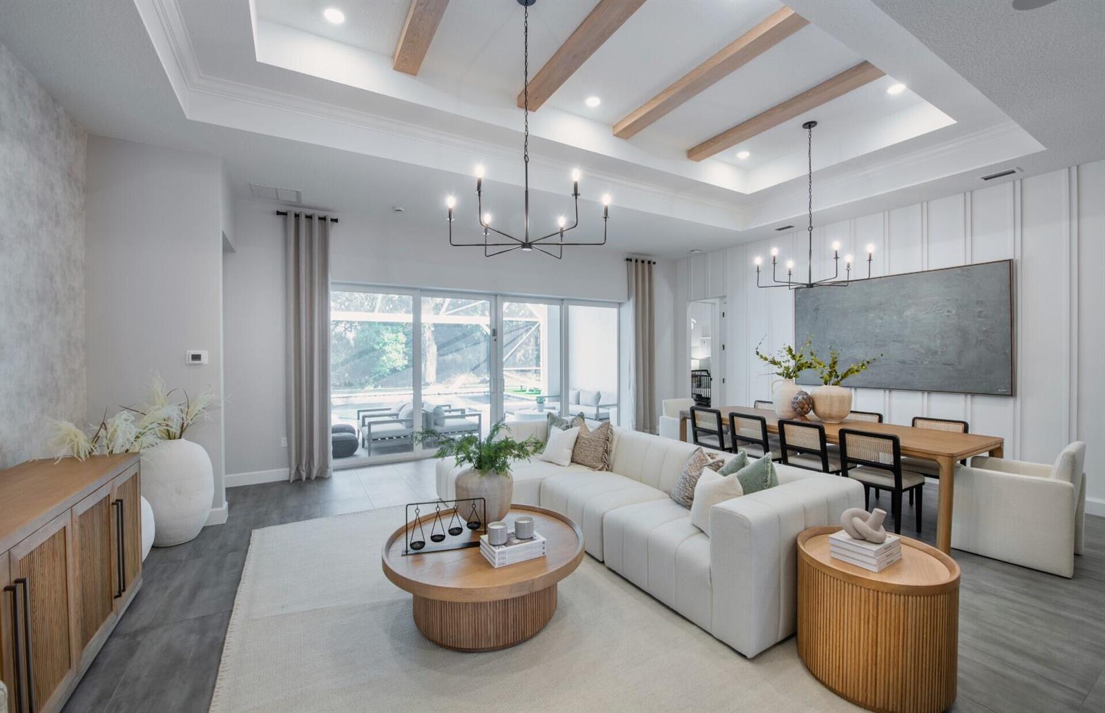 A bright open-concept living and dining area features a coffered ceiling with wood beams — 4425 SW Cornerstone Way # 169, Stuart FL 34997, STUART, FL