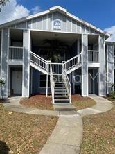 A two-story apartment building exterior features a central staircase leading to the upper level — 718 SUGAR BAY WAY UNIT 202, LAKE MARY, FL