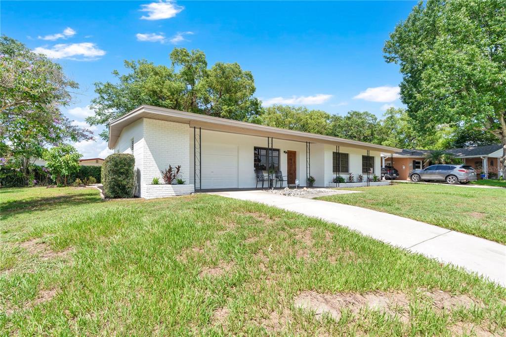 A single-story white brick house with a flat roof and a front porch — 5301 BRERETON AVENUE, ORLANDO, FL