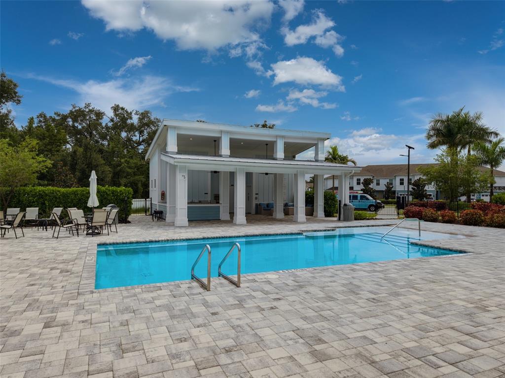 A living room with a gray sectional sofa, two armchairs, and an open-concept kitchen — 254 VIA ANINA DRIVE, SARASOTA, FL
