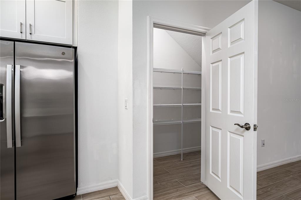 A kitchen features white cabinets, marble-look countertops, a subway tile backsplash, and a stainless steel sink — 254 VIA ANINA DRIVE, SARASOTA, FL