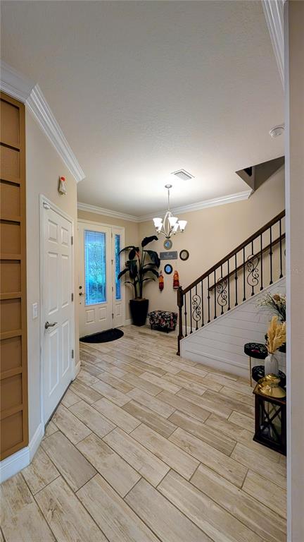 An entryway features light wood-look tile flooring, a staircase with iron railings, and a front door — 2468 WHITTLER BR BRANCH, ODESSA, FL