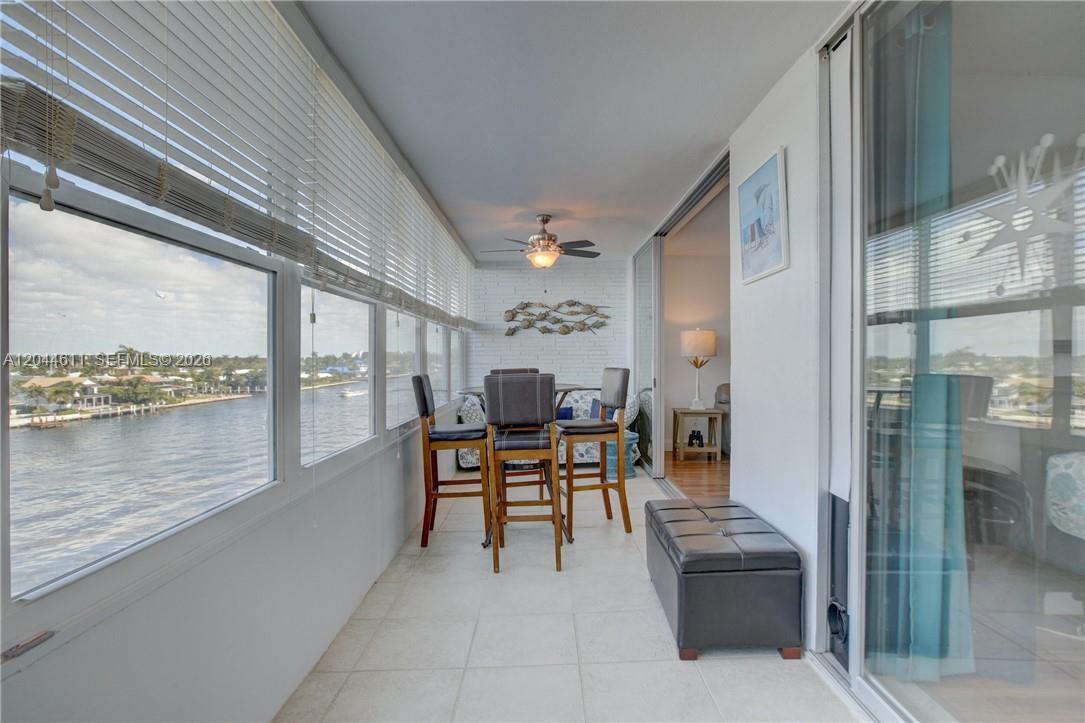 An aerial view of a canal with waterfront houses, docks, and a boat moving forward — 401 N Riverside Dr # 504, Pompano Beach FL 33062, POMPANO BEACH, FL