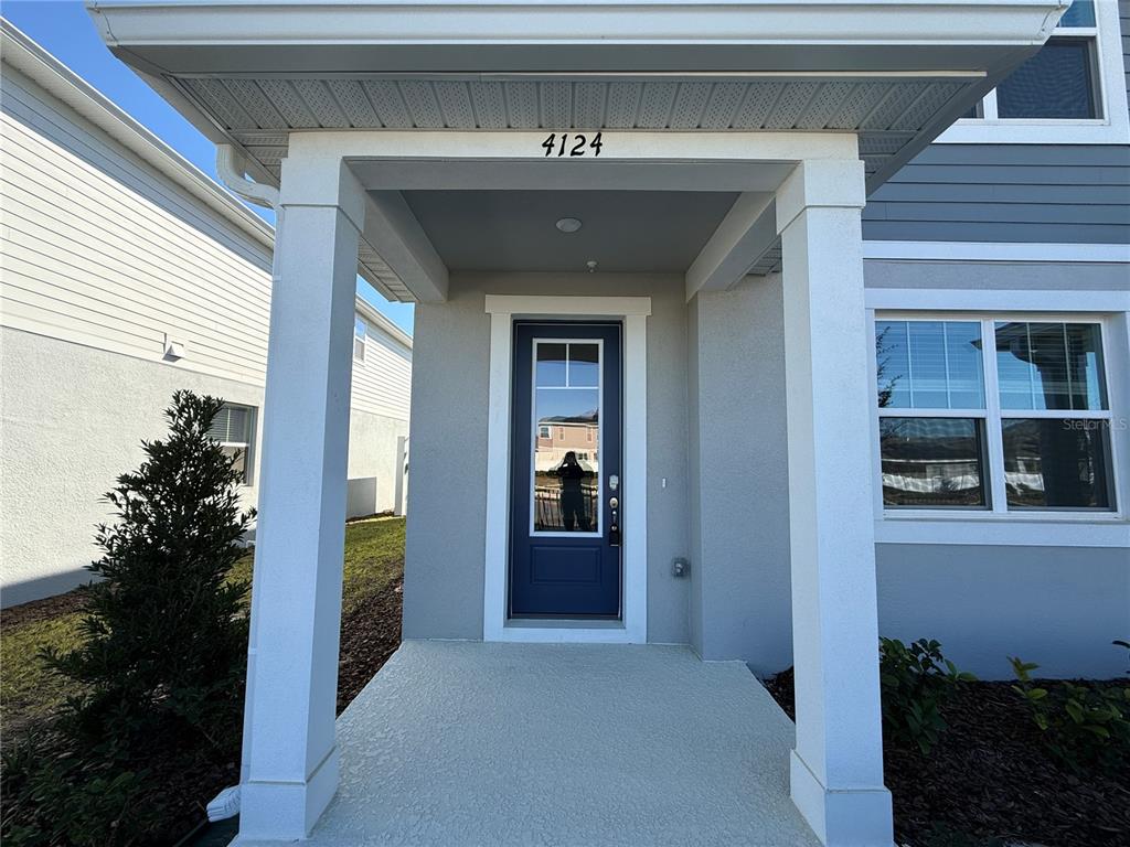The front entrance features a covered porch with white columns and a dark blue door — 4124 SADLER ROAD, APOPKA, FL