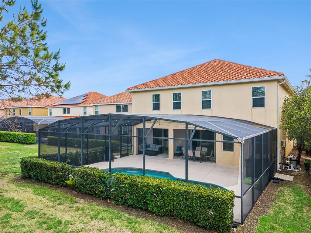 A two-story house with a screened-in pool and patio area in the backyard — 4348 ACORN COURT, DAVENPORT, FL