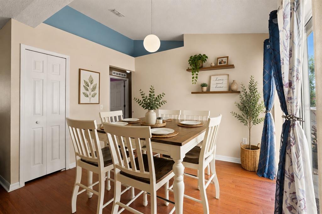 A dining room with a wooden table, white chairs, floating shelves, and blue accent walls — 4416 DIOR ROAD, SPRING HILL, FL